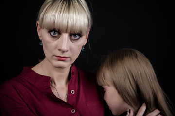 A woman puts her arms around her child, trying to calm him down. The child is seven years old.