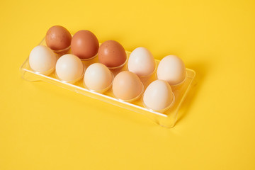 Eggs on a yellow background. Chicken eggs on a wooden board