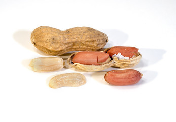 peanuts in the foreground on white. Close up of closed and peeled peanuts. Composition from nuts on the white isolated background