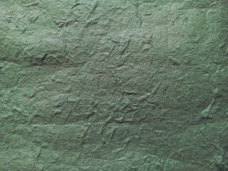 Wrinkled green paper textured background. Mulberry paper. Rice paper texture.