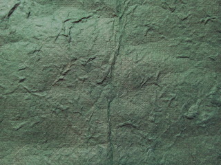 Wrinkled green paper textured background. Mulberry paper. Rice paper texture.