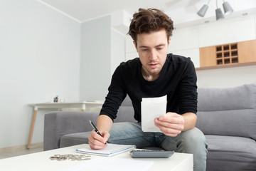 Man holding receipt, making financial revision