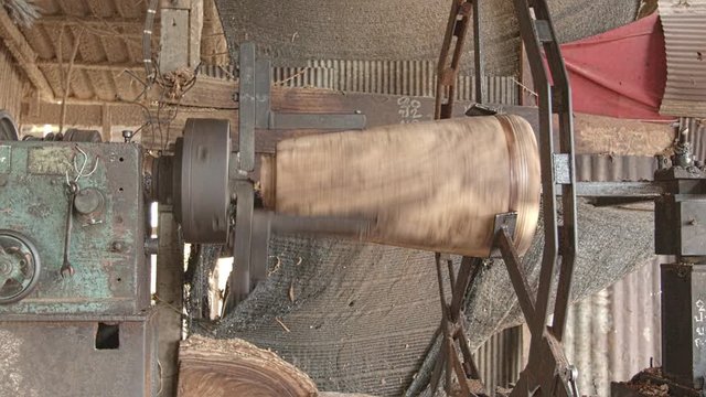 Workers forming long drum By using a rotating motor and using sharp object for forming