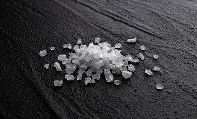 Fototapeta na wymiar Pile of sea salt on black background