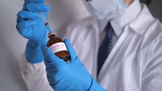 Medical doctor or laborant holding tube with nCoV Coronavirus vaccine for 2019-nCoV COVID virus. Novel Coronavirus originating in Wuhan, China. Coronavirus 2019-nCoV COVID concept.