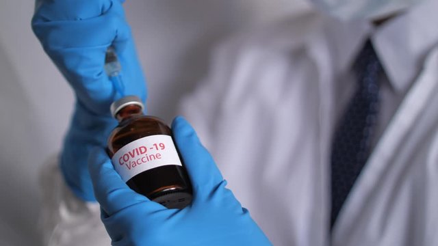 Medical doctor or laborant holding tube with nCoV Coronavirus vaccine for 2019-nCoV COVID virus. Novel Coronavirus originating in Wuhan, China. Coronavirus 2019-nCoV COVID concept.