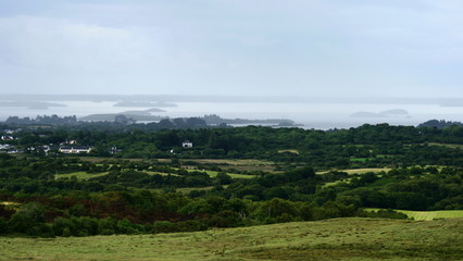 Fototapeta na wymiar beautiful green summer landscape from Connemara, Galway, Ireland overlooking Lough Corrib and the local forests and villages