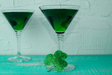 St. Patrick's Day concept. Green drink, green cocktail in a glass, horseshoe and clover leaf