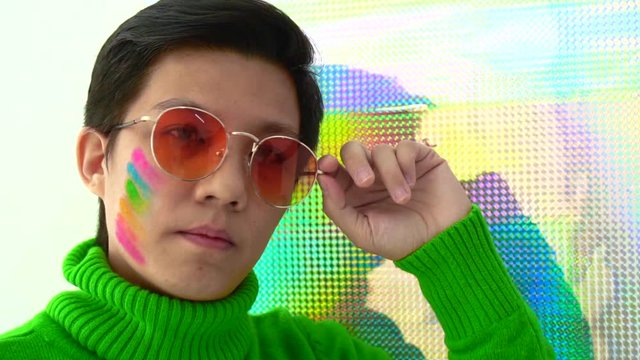 Asian woman support LGBT concept rainbow make up on face and glitter background