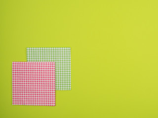 Plaid paper napkins on green background.