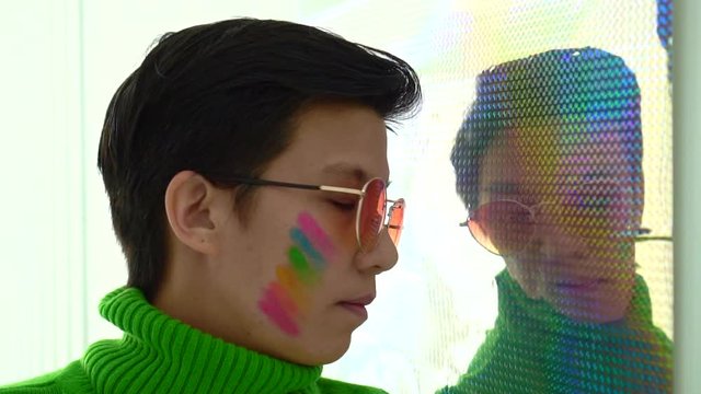 Happy reflection of Asian LGBT woman support homosezual rights rainbow make up on face