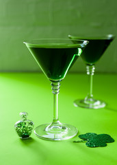 St. Patrick's Day concept. Green drink, green cocktail in a glass, horseshoe and clover leaf