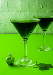 St. Patrick's Day concept. Green drink, green cocktail in a glass, horseshoe and clover leaf