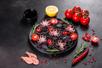 Black seafood pasta with shrimp, octopus and mussels on black background. Mediterranean gourmet food