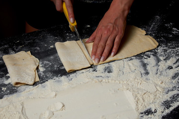 Baker prepares homemade cakes. Professional Female cook sprinkles dough with flour, prepared for baked bread