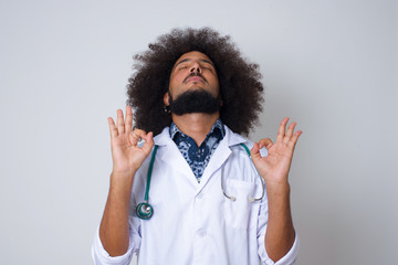 Meditation, religion and spiritual practices. Beautiful young doctor male doing yoga in the morning...