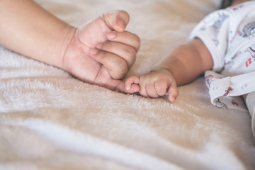 Mom and baby making a pinkie promise. Mother's love concept.