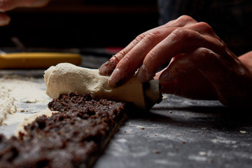 Baker prepares homemade cakes. Professional Female cook sprinkles dough with flour, prepared for baked bread