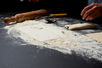 Baker prepares homemade cakes. Professional Female cook sprinkles dough with flour, prepared for baked bread