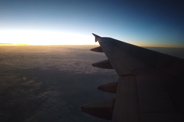 Fototapeta na wymiar 航空機の窓から見える雲海と夕日