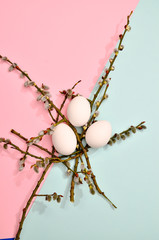 White eggs with green myrtle leaves pattern on vibrant pastel color background. Spring and Easter...