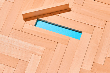 Wooden planks laid with a herringbone pattern on a light blue background in the center is an empty space for Your text. Abstract background.