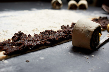 Professional Female cook sprinkles dough with flour, prepared for baked bread