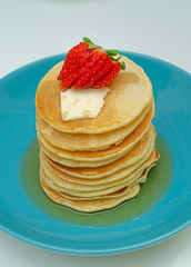 stack of pancakes with maple syrup and berries