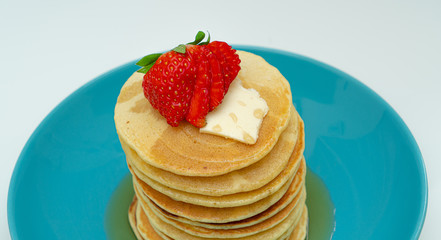 stack of pancakes with maple syrup and berries