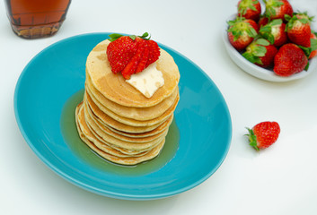 stack of pancakes with maple syrup and berries