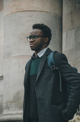 Fototapeta na wymiar Black student with glasses and a bag in his shoulder