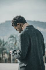 Young black man looking at his mobile