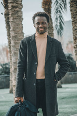 portrait of a young man with palm trees behind him