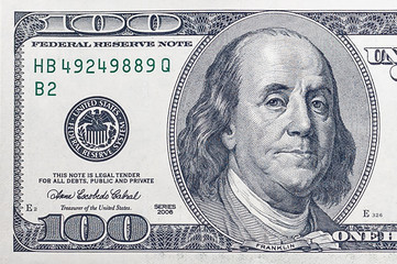 left side of a hundred-dollar bill USA with a portrait of American President Benjamin Franklin.