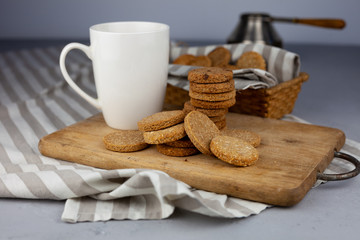 White cup with place for text. Breakfast is on the table. Cup with coffee and round homemade cookies. Mug with a drink and a snack. Mockup for designs. 