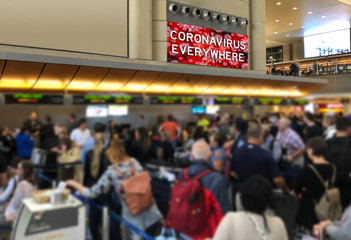 People crowd at airport check in desk with Corona Virus Sign