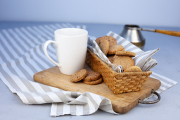 White cup with place for text. Breakfast is on the table. Cup with coffee and round homemade cookies. Mug with a drink and a snack. Mockup for designs. 