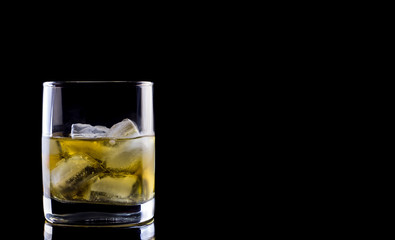 Tumbler glass with whiskey on black background