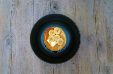 stack of pancakes with maple syrup and bananas