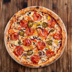 Hot chorizo pizza with chorizo sausage, jalapenos and bell pepper on a table in italian restaurant