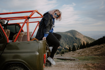 Obraz premium young woman on top of the mountain. extreme mountain jeep riding