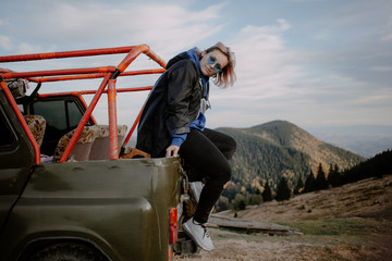 Obraz premium young woman on top of the mountain. extreme mountain jeep riding