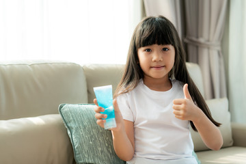 Asian child girl using alcohol antiseptic gel and thumb up, prevention, cleaning hands frequently, prevent infection, outbreak of Covid-19,girl wash hands with hand sanitizer 