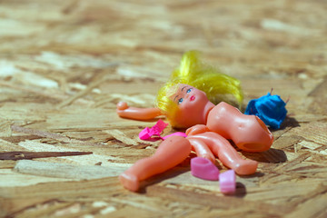 Doll body parts on a wooden background. Copy space. Top view