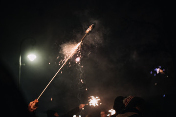hand with burning firecracker rocket , rather dangerous