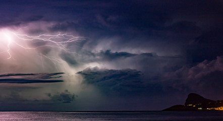 Lightning storm in the night sky over the mediterranean sea in San Antoni, Ibiza  - obrazy, fototapety, plakaty