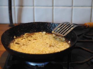 Cabbage is fried in a black cast iron pan on the kitchen stove.Natural home-made food.