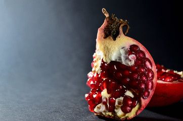 a piece of red pomegranate stands upright with a copy space horizontal orientation