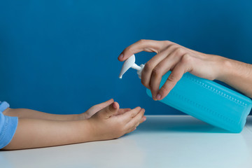 mom pours liquid soap on the palm of the child during the epidemic