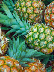 Several ripe pineapples stacked in a fruit market